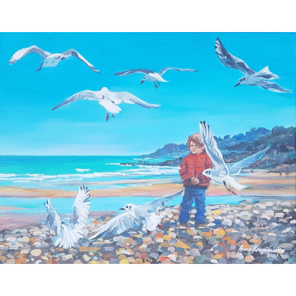 A boy playing with the seagulls
